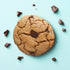 Top down view of the chocolate chunk UniCookie, The Regular Cookie, on a pastel blue backdrop.